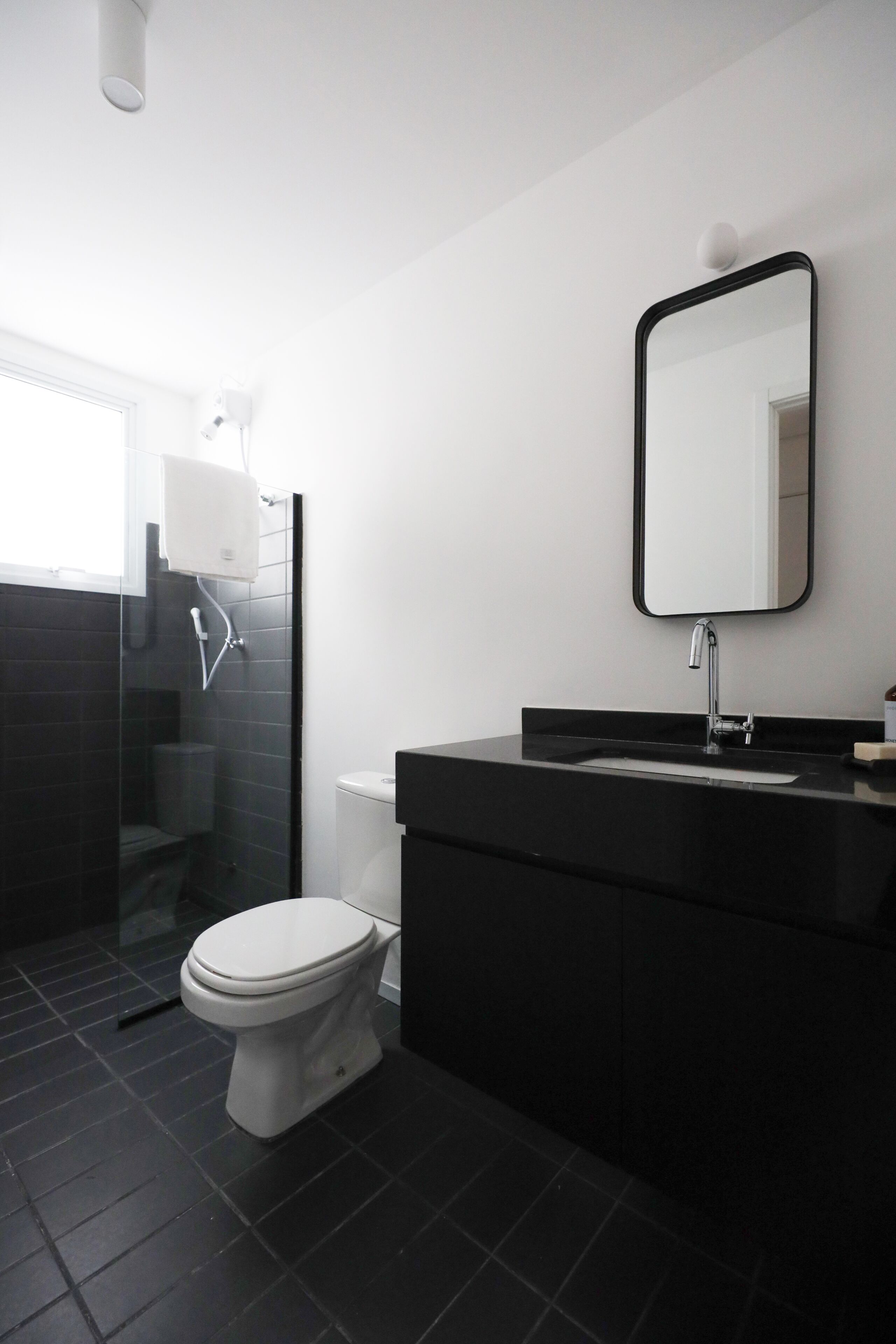 Un baño moderno con inodoro, lavamanos y ducha.