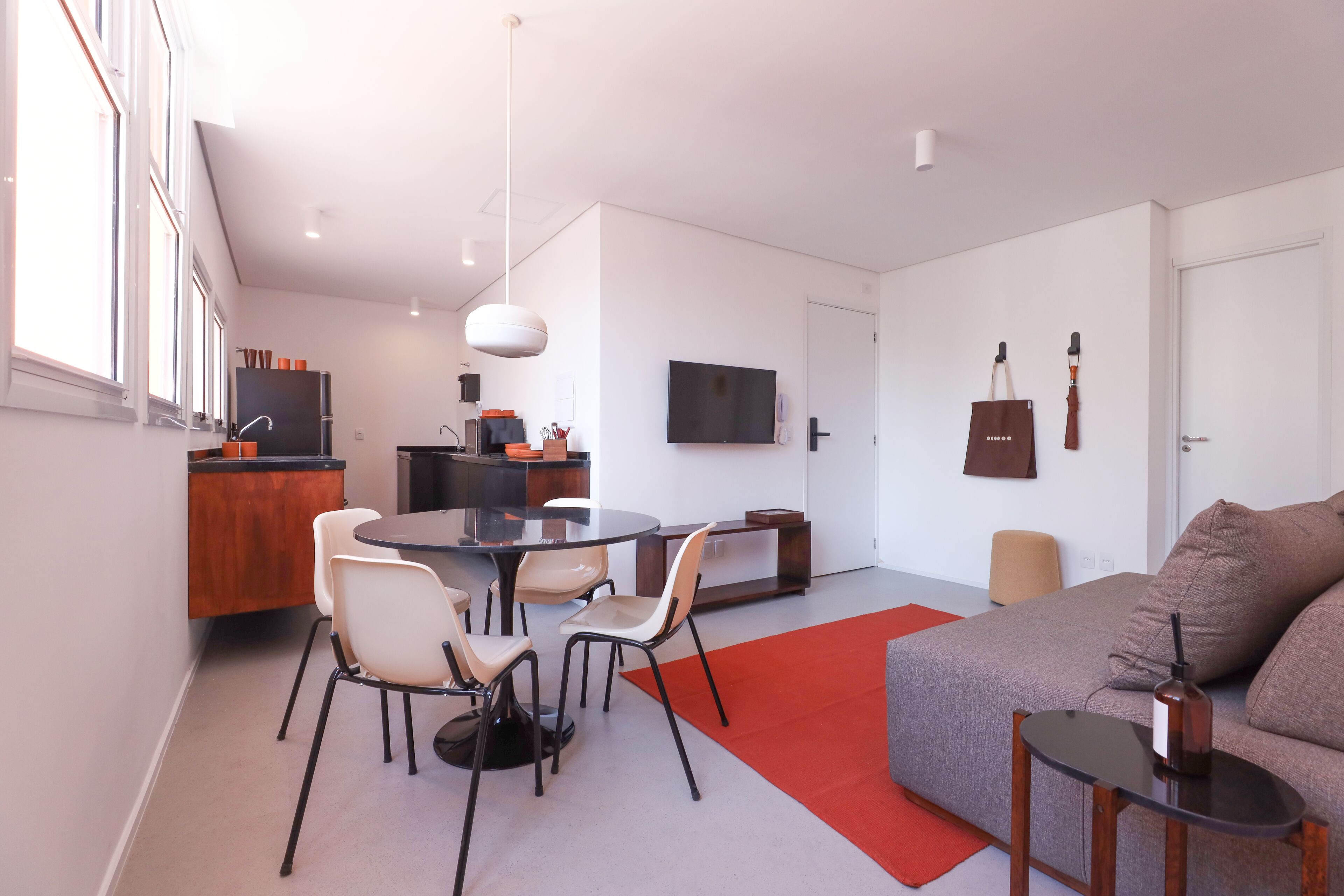 Un espace de vie moderne comprenant un coin repas, un canapé et un téléviseur.