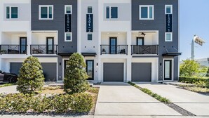 Un moderno edificio residenziale a più piani, con balconi numerati e basculanti del garage.
