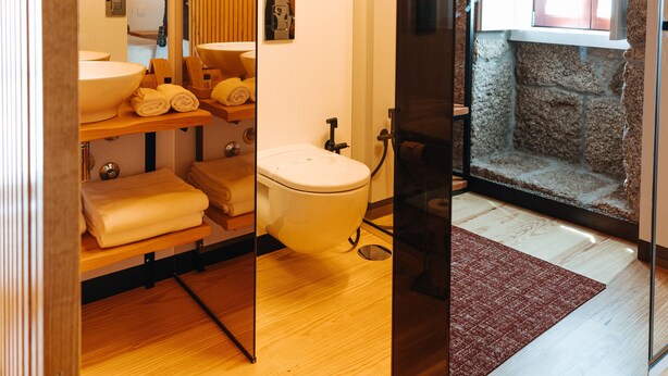 A bathroom with wooden beams, a large mirror, a sink, and a window. - D'Autor Village (Baiao)