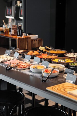 Buffet com diversos alimentos e etiquetas.