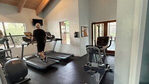 A gym with treadmills, exercise bikes, and a ceiling fan. - Cozy Condo in Ventana Canyon, 5 mins to Sabino Canyon. Pools, gym, hiking trails (Tucson)