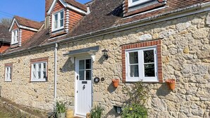 A stone house with a white door, multiple windows, and a red-tiled roof. - 3 bedroom accommodation in Calbourne (Calbourne)