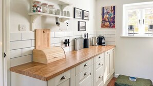 A kitchen with white cabinets, a wooden countertop, and a window with a view. - 3 bedroom accommodation in Calbourne (Calbourne)