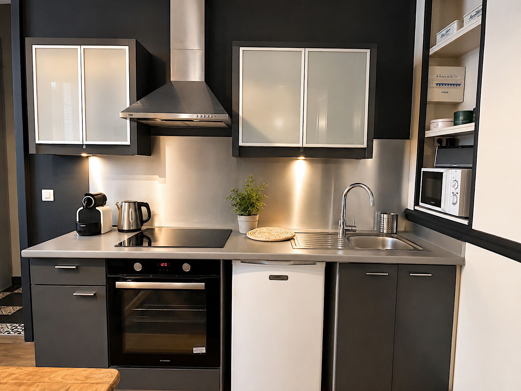 Una cocina moderna con electrodomésticos de acero inoxidable, horno empotrado y microondas.