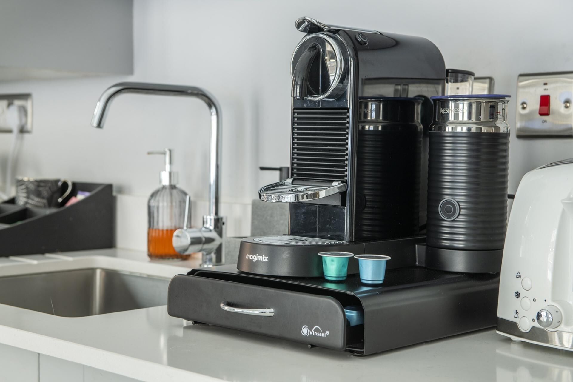 Una cocina moderna con cafetera, lavaplatos y tostadora.