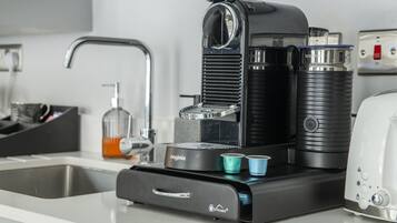 Una cocina moderna con cafetera, lavaplatos y tostadora.