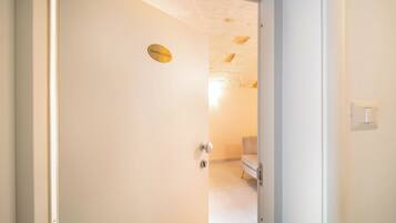 A door with a sign reading 'SANTA LUCIA' leading into a room with a white wall and a ceiling with exposed stonework.