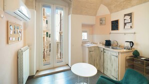 A compact kitchen with a sink, stove, and a small table. - Le Contrade Chiasso Cafaro (Monopoli)