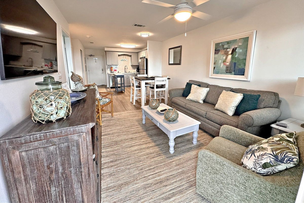 A living room with a sofa, chairs, a coffee table, and a dining area with a table and chairs.