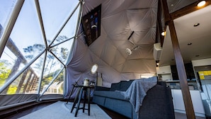 A tented interior with a sofa, a small table, and a view through the window. - The Domes Jarabacoa (Jarabacoa)