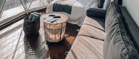 A geodesic dome room with a sofa, a round coffee table, and a wall-mounted TV.