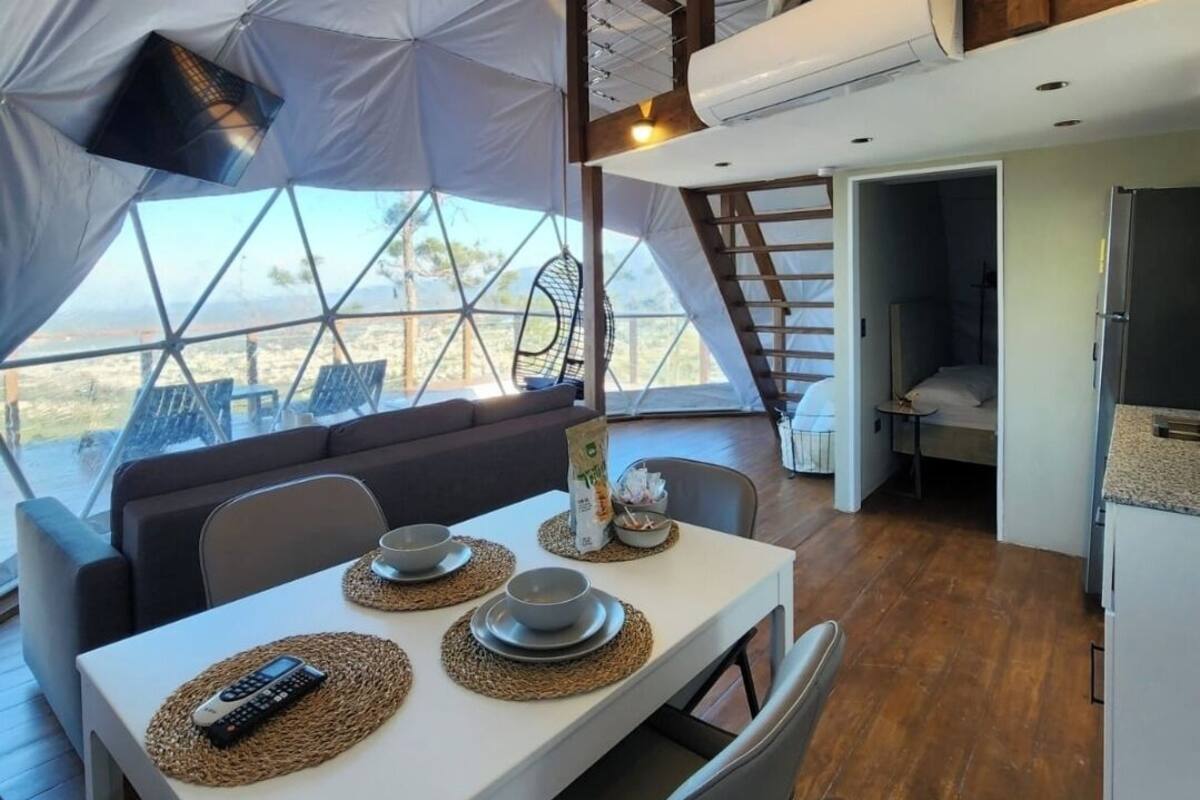 Une tente comprenant un espace repas, une cuisine et un coin nuit.
