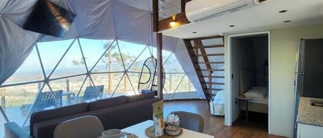 Una carpa con comedor, cocina y zona de descanso.
