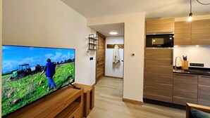 A modern kitchen with wooden cabinets and a built-in oven. - PEARL 001 | LES GETS | Centrer - 4/5 pers. (Les Gets)