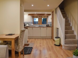 A modern kitchen with wooden cabinets, a built-in oven, and a window above the sink.