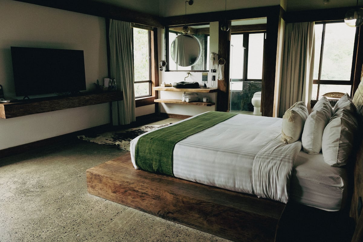 Une chambre à coucher avec un lit, une télévision, un miroir et une fenêtre.