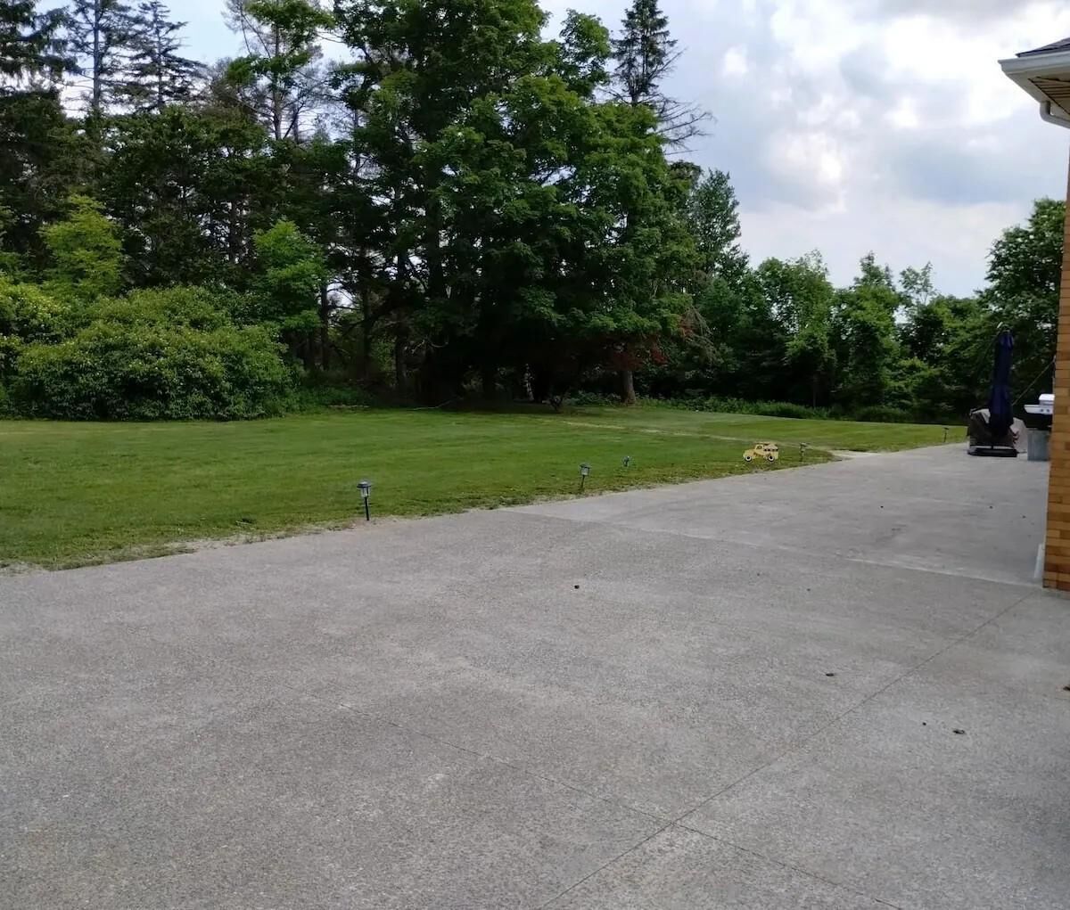 A paved driveway leading to a building with a brick exterior.