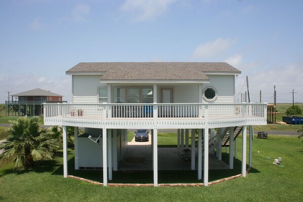 A two-story house with a balcony and a covered porch.