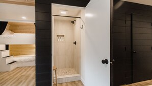 A modern room with a bunk bed, a shower area, and a black wardrobe. - Wonderstone Bunkhouse (Individual Bed) (Columbia Falls)