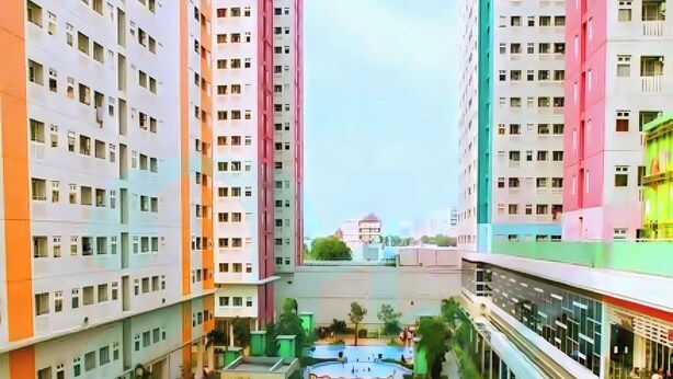 Un edificio residencial de varios pisos con un patio central que cuenta con una piscina y zonas de estar.