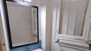 Ein Badezimmer mit Waschbecken, Spiegel und Fenster.