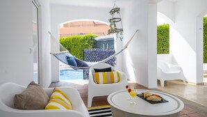 A modern room with a hammock, a pool, and a dining area. - Villa with BBQ and heatable pool in Vilamoura (Quarteira)