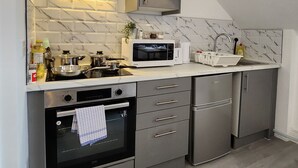 Una cocina moderna con electrodomésticos de acero inoxidable, salpicadero de mármol y horno empotrado.