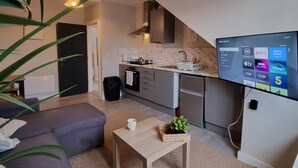 A modern living room with a sofa, a coffee table, and a TV.
