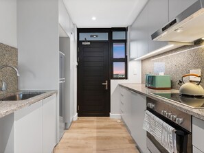 Enjoy cooking in this well-equipped kitchen with an oven, range hood, and stainless steel sink.