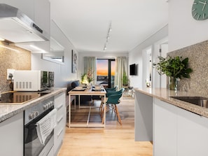 Enjoy cooking in this well-equipped kitchen with a range hood, microwave, and large oven, complemented by a dining table and window with a view.