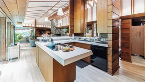 Una cocina moderna con una isla grande, armarios de madera y salpicadero de piedra.