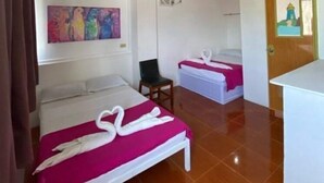 A hotel room with two beds, a chair, a desk, and artwork on the walls. - Executive Oasis: Stylish Living in Puerto Princesa (Puerto Princesa)