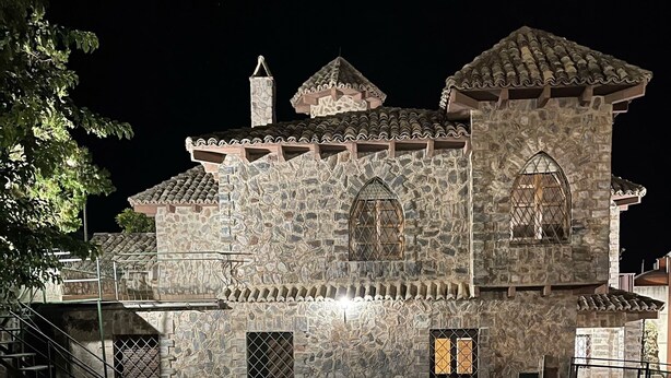 Ein Steinhaus mit Schwimmbecken bei Nacht.
