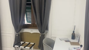 Una habitación con escritorio, silla y un tendedero.