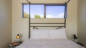 Une chambre à coucher avec un lit, une fenêtre et deux lampes de chevet.