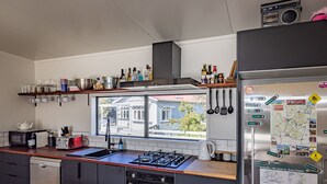 Une cuisine moderne équipée d’une cuisinière à gaz, d’un four, d’un lave-vaisselle et d’un réfrigérateur décoré d’une carte et d’aimants.