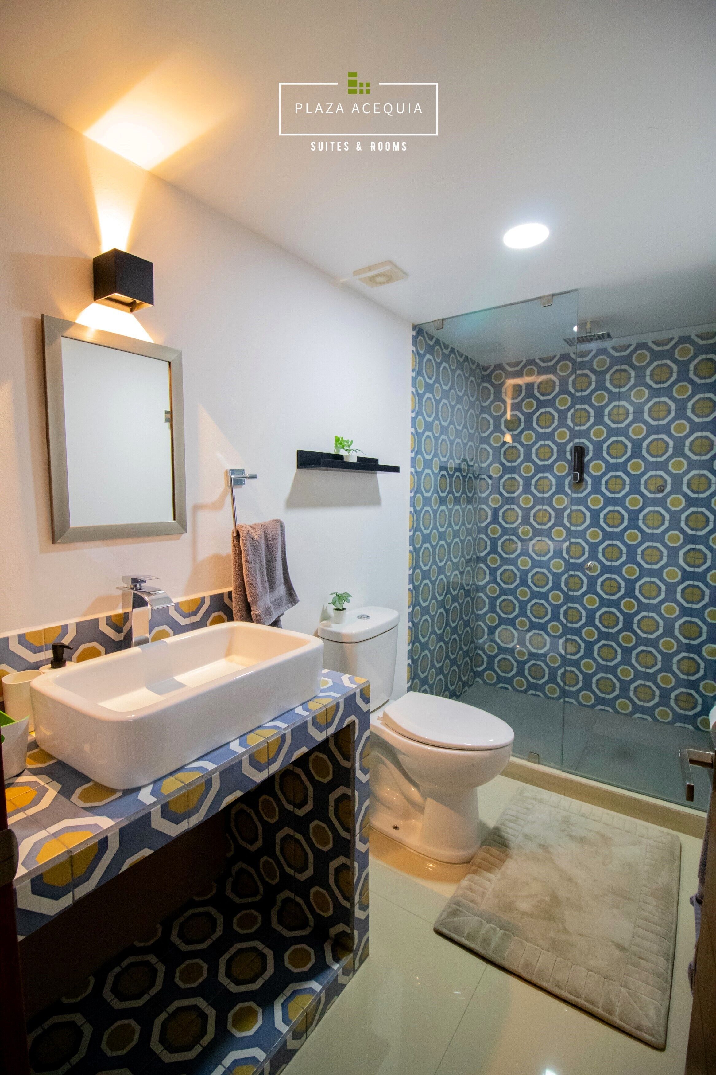 Un baño moderno con lavamanos amplio, inodoro y zona de ducha.