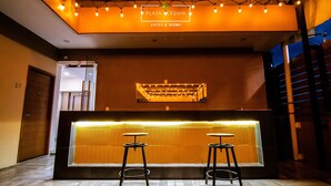 A reception area with a sign reading "PLAZA ACEQUIA SUITES & ROOMS". There are two stools and a reception desk with a lighted panel. - A07 SUPER CITY SUITES AT PLAZA ACEQUIA (Cuautitlan Izcalli)