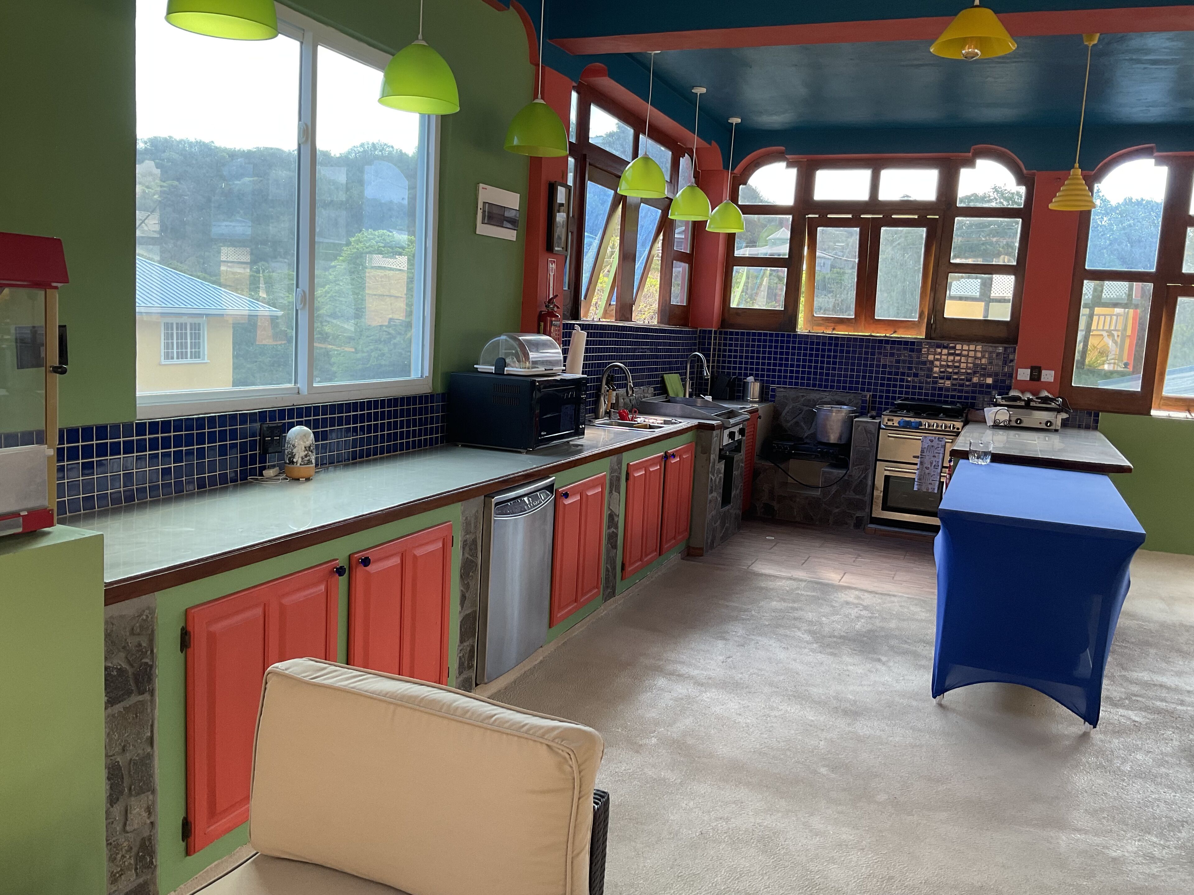 A kitchen with a large window, a sink, a stove, and a refrigerator.