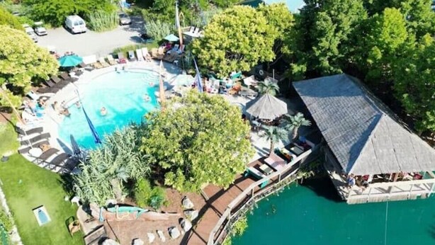 An aerial view of a resort with a large swimming pool, a dock, and a covered area with umbrellas. - Middle Bass Island retreat,10-min ferry ride to Put-in-Bay, Pet friendly! (Middle Bass)