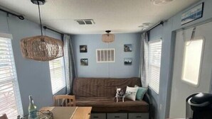 A compact living space with a sofa, a dining table, and a kitchen area. - Middle Bass Island retreat,10-min ferry ride to Put-in-Bay, Pet friendly! (Middle Bass)