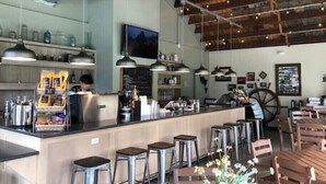 A café interior with a bar area, stools, and a vintage wheel. - Middle Bass Island retreat,10-min ferry ride to Put-in-Bay, Pet friendly! (Middle Bass)