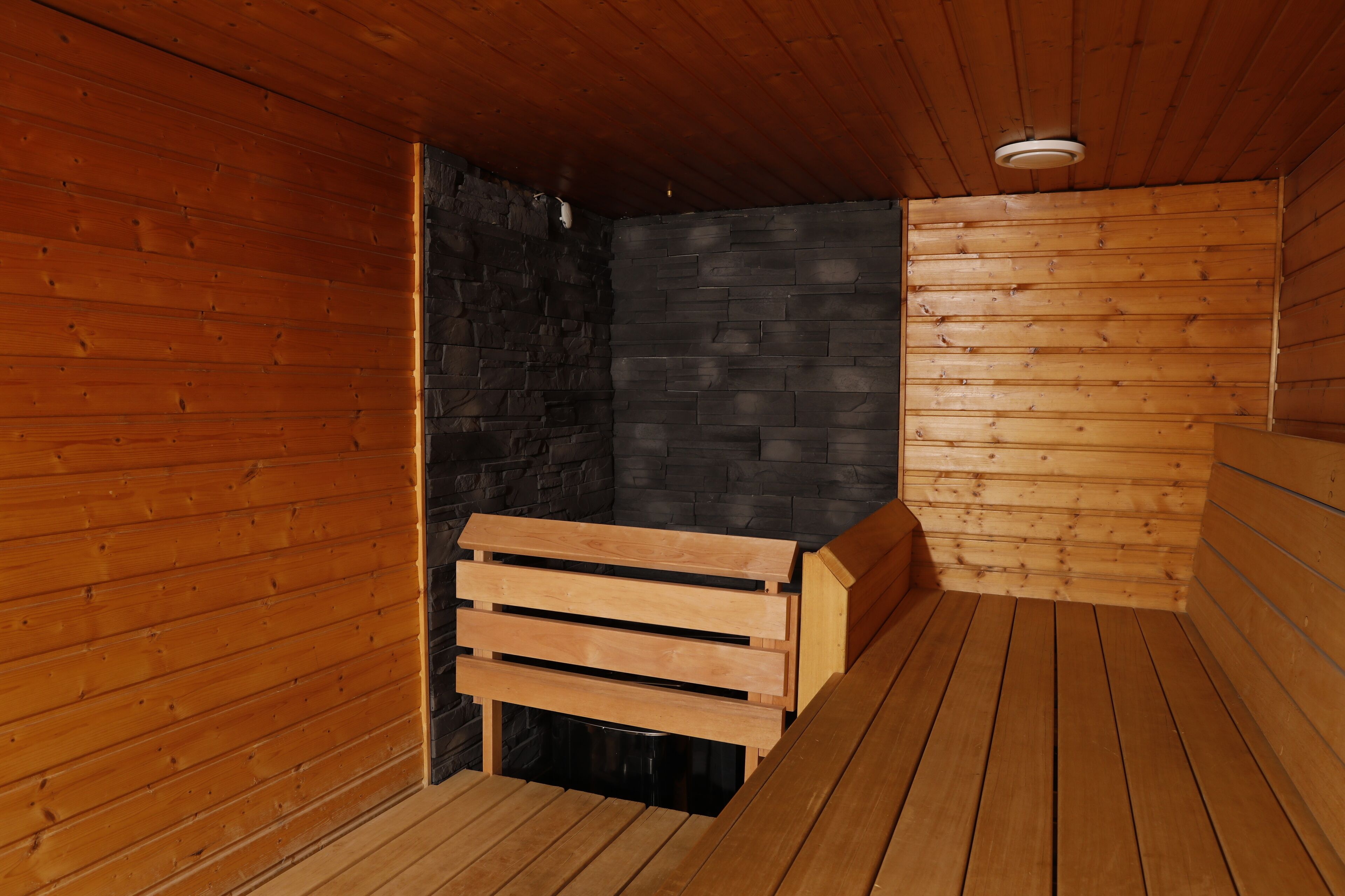 A sauna room with wooden walls and benches.