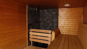 A sauna room with wooden walls and benches.