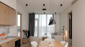 A modern kitchen with a marble countertop, wooden cabinets, and a dining area with a wooden table and chairs.