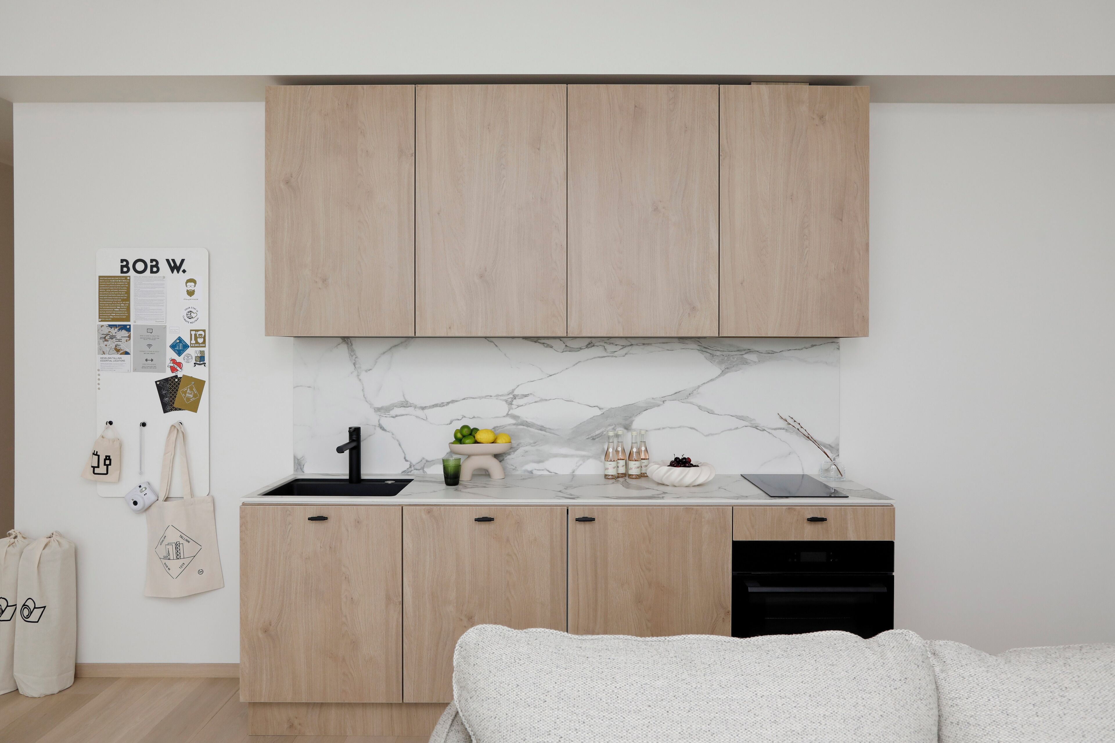 Una cocina moderna con armarios de madera, un salpicadero de mármol y un fregadero.