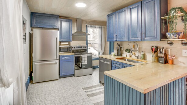 A modern kitchen with blue cabinets, stainless steel appliances, and a central island. - Charming Minneapolis Home w/ Deck, 5 Mi to Central (Minneapolis)