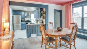 A dining area with a wooden table and chairs, a ceiling fan, and a view of the kitchen in the background. - Charming Minneapolis Home w/ Deck, 5 Mi to Central (Minneapolis)