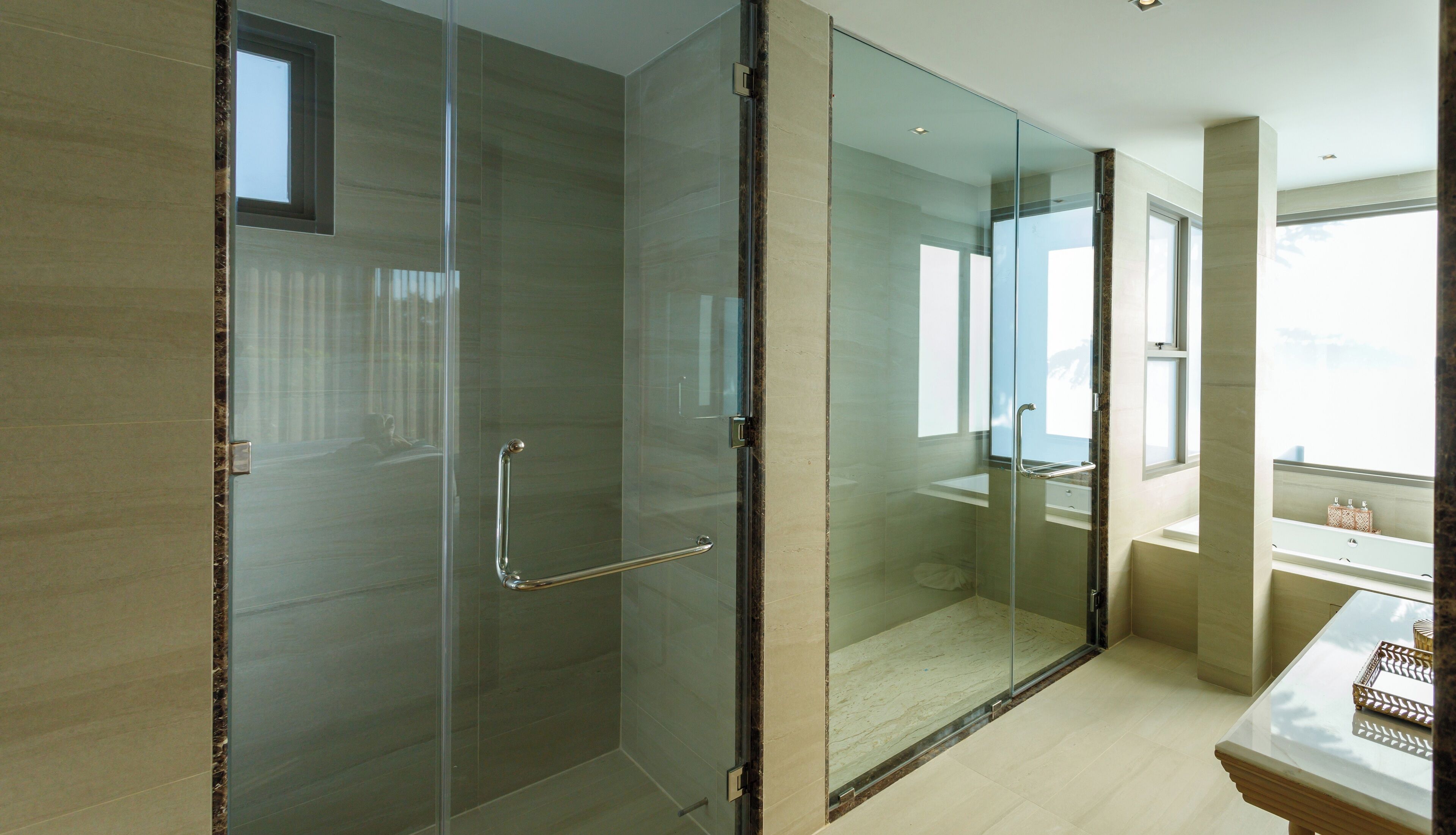 Un baño moderno con cabina de ducha de vidrio, bañera y tocador con espejo.